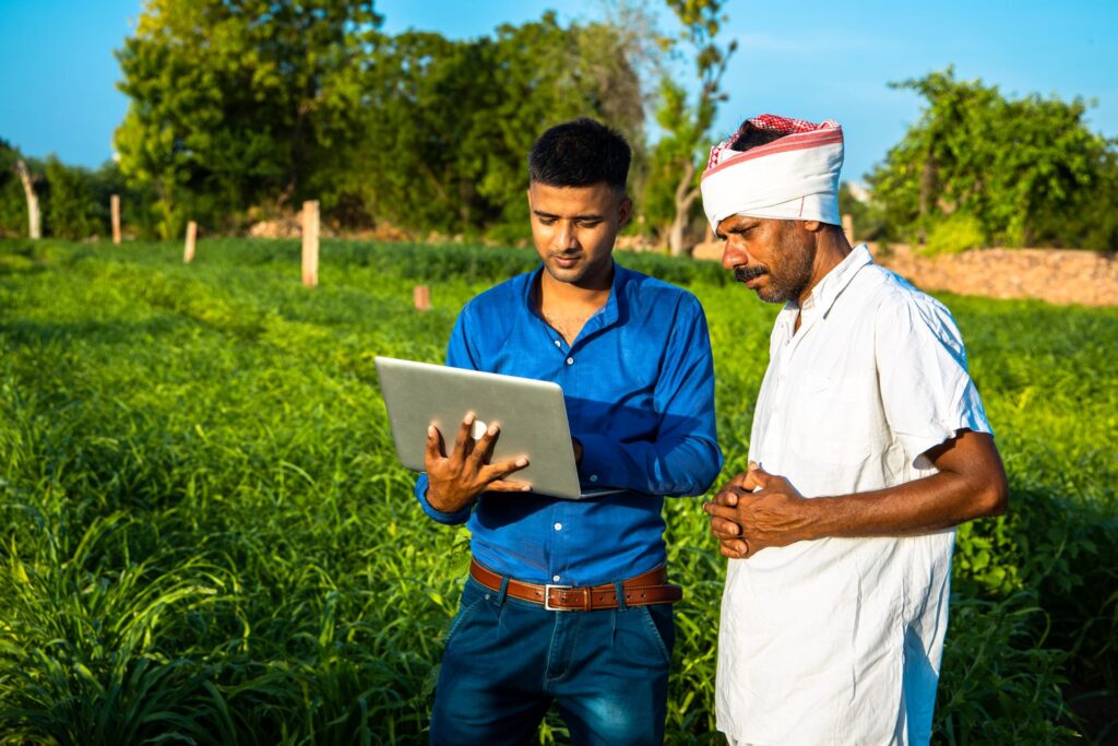 Two farmers look at data on a tablet.