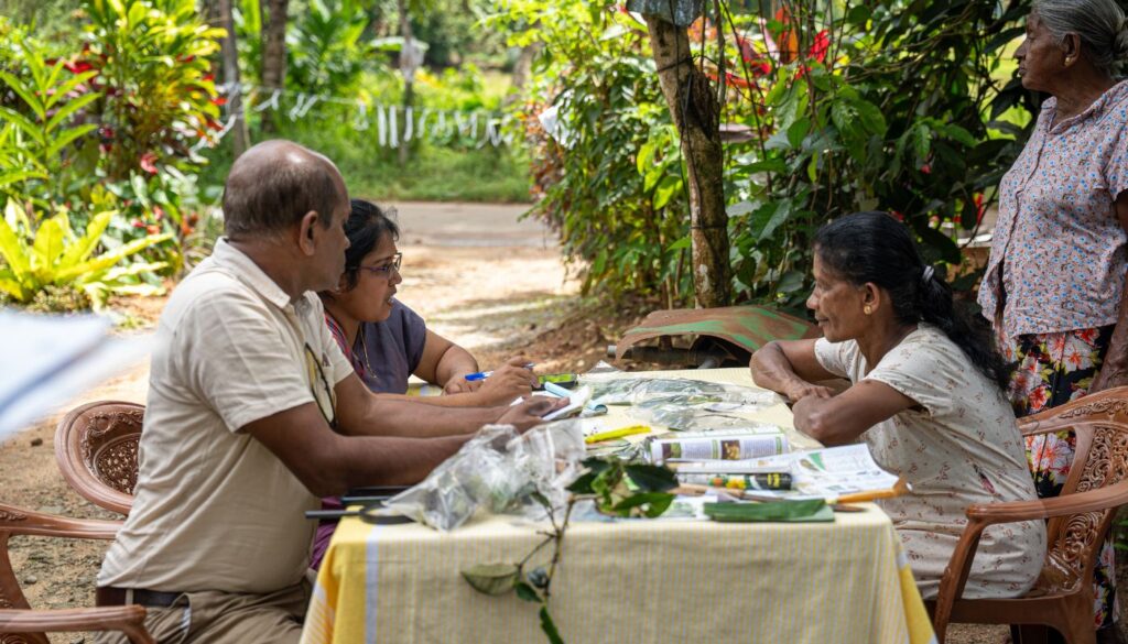 Agricultural advisors provide a farmer with advice at a plant clinic in Sri Lanka